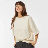 Camiseta beige de cuello redondo y corte oversize.