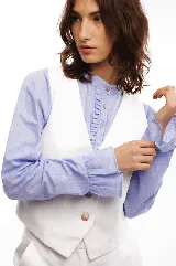 Chaleco de vestir blanco con cuello en V y cierre frontal con botones.