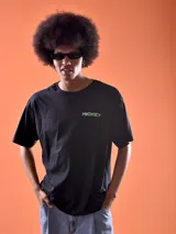 Remera negra de corte oversized con estampado pequeño en el pecho con la palabra "Mickey" en color verde.