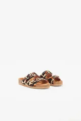Sandalias de cuero vacuno con estampado animal print, forro de cuero vacuno y suela de caucho. Presentan dos tiras con hebillas ajustables y apliques de tachas metálicas.