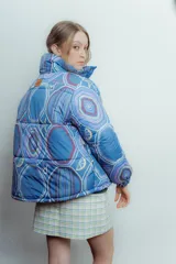 Campera puffer azul con estampado geométrico en tonos violeta, celeste y blanco.