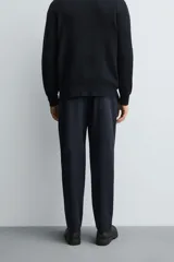 Pantalón regular fit color azul marino, confeccionado en tejido elástico. Cuenta con bolsillos frontales, bolsillos traseros de vivo con botón y cierre frontal con cremallera y botón.