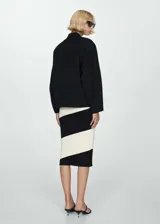 Chaqueta bomber negra con cierre frontal y bolsillos laterales.