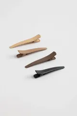Set de cuatro pinzas para el pelo tipo cocodrilo, en colores beige claro, beige oscuro, marrón y negro.