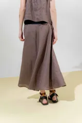 Falda midi de lino color gris claro, de silueta amplia y pretina elastizada color beige.
