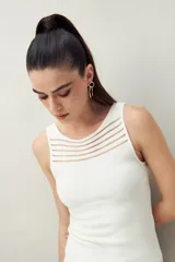 Top negro sin mangas de tejido acanalado con transparencias lineales en el escote.