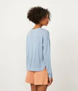 Blusa celeste de viscosa con cuello redondo, mangas largas y puños con botones.