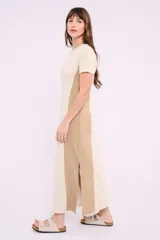 Vestido largo de tejido de punto acanalado color beige claro, con paneles laterales lisos en color marrón. Tiene mangas cortas y cuello redondo.