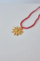 Collar dorado con dije de acero quirúrgico hipoalergénico en forma de girasol y cadena de cordón trenzado color dorado.