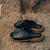 Sandalias bajas de cuero vacuno color negro, con suela de goma y horma de punta redonda. Producto de horma chica, se recomienda pedir un talle más.