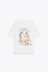 Camiseta blanca de corte recto y manga corta, con cuello redondo. Estampado frontal con dos mujeres en la playa y texto "Beach Days Best Days".