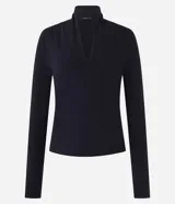 Blusa negra de mangas largas confeccionada en viscosa, con cuello alto, escote V y aberturas en los hombros.