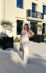 Mono color beige con breteles anchos, corte a la cintura con botón decorativo y pantalón palazzo con diseño cruzado.