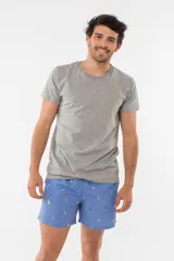 Short de baño azul con estampado de hojas de palmera en tonos azules, blancos y rosados.