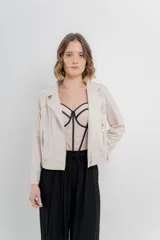 Chaqueta color beige de tela tipo gamuza con elastano, cuello solapa, manga larga con trabillas en hombro, bolsillos delanteros con cremallera metálica y cierre frontal con cremallera.