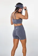 Conjunto deportivo gris jaspeado compuesto por top con breteles finos y logo 'bk.' estampado en el frente, y short de calce ajustado.