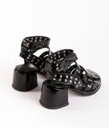 Sandalias de cuero color bordó con tres tiras horizontales sobre el empeine y pulsera al tobillo, ambas con apliques de tachas plateadas.