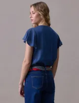 Blusa celeste de tencel con escote en V y botones. Tiene mangas cortas amplias con volados.
