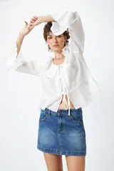 Minifalda de jean celeste con tiro bajo y detalle de tachas metálicas en los bolsillos.