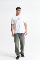 Pantalón jean celeste de corte carpenter, tiro medio, con presillas para cinturón y bolsillos laterales.