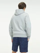 Buzo hoodie gris de Tommy Hilfiger con logo bordado en el pecho, cordones blancos y bolsillo tipo canguro.