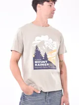 Remera blanca de corte recto con estampa fotográfica de edificios en la parte frontal.
