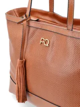 Cartera shopper negra de cuero vacuno con perforaciones y logo metálico de la marca. Incluye un colgante con borla de cuero.