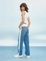 Pantalón de jean azul con cintura blanca y raya blanca lateral.