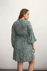 Vestido corto con estampado animal print en tonos verde y blanco, escote en V y mangas 3/4 acampanadas.