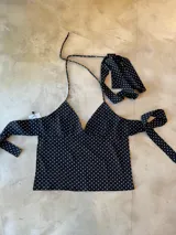Top halter negro con lunares blancos, de tela tipo gasa, para atar al cuello y con espalda descubierta. Incluye corbatín.