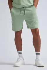 Bermuda deportiva verde con cintura elástica y cordón ajustable.