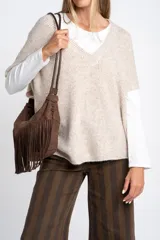 Chaleco de punto oversize con escote en V, hombros caídos y textura acanalada en color beige, confeccionado en una mezcla de acrílico, poliéster, nylon, lana y spandex.