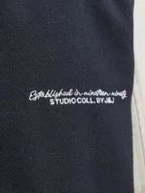 Campera bomber de manga larga y cuello estilo baseball, color azul marino con mangas beige. Tiene cierre de botones, puños acanalados y bolsillos delanteros. Confeccionada en tejido plano con detalle de logo.