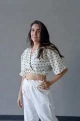 Top cruzado escotado de tusor de algodón con estampado de lunares verdes, cintura elastizada y manga corta holgada.