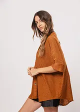 Camisa marrón con calados, escote en V, abotonada y manga 3/4.