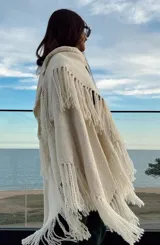 Ruana color crudo de tejido artesanal en telar manual con hilado zigzag y flecos.