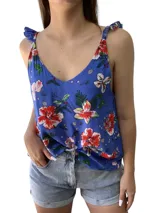 Blusa sin mangas azul con estampado floral en tonos rojos y verdes, con tirantes nudados en los hombros.