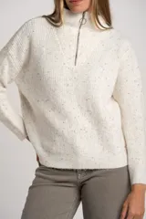 Sweater de tejido de punto color blanco roto, con motas de colores (efecto tweed o confetti), cuello alto con cierre metálico parcial y calce oversize.
