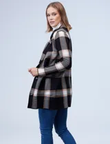 Cardigan tejido de mujer, color negro con diseño de cuadros grandes en blanco y beige/tostado. Presenta cuello con solapa y abertura frontal con botones, y bolsillos aplicados.