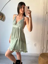 Vestido corto verde agua con escote halter, espalda descubierta y falda con volados de tul con lunares.