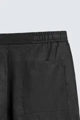 Bermuda negra de lino con calce relajado. Presenta cintura elástica ajustable con cordón, bolsillos frontales y un bolsillo trasero de plastrón.