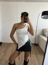 Top blanco de lycra, con un solo hombro y corte irregular en la parte inferior.