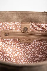 Bolso tipo tote bag grande color marrón, confeccionado en cuero vegano, con doble asa de hombro y detalle de pañuelo estampado atado a una de las asas.
