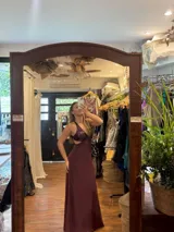 Vestido largo negro con escote en V, cut outs laterales bajo el busto y breteles finos cruzados y atados en la espalda.