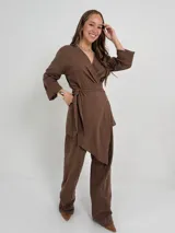 Conjunto color beige de lino, compuesto por un blazer cruzado con lazo para atar y un pantalón de corte recto con cintura elástica.