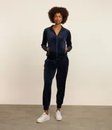 Conjunto deportivo azul marino de terciopelo, compuesto por una chaqueta con cierre y un pantalón jogging con cintura elástica.