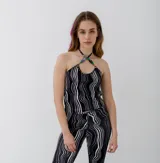 Top negro con estampado de rayas onduladas blancas, cuello halter con cuentas de colores y espalda descubierta.