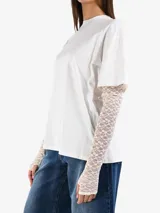 Camiseta blanca de algodón con mangas cortas y mangas largas de encaje color crema debajo.
