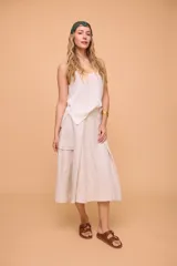 Pollera midi color beige de lino, con cintura ajustable con botón y bolsillo cargo en el lateral.