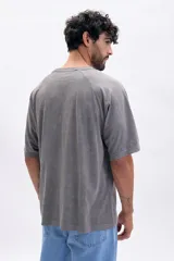 Remera gris de manga corta ranglan con estampa frontal que dice "Underground Movement Street-Made Identity".